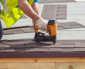 Worker install tiles on roof with machine