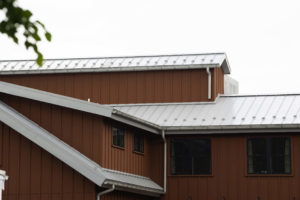Modern standing seam white metal roof on house.