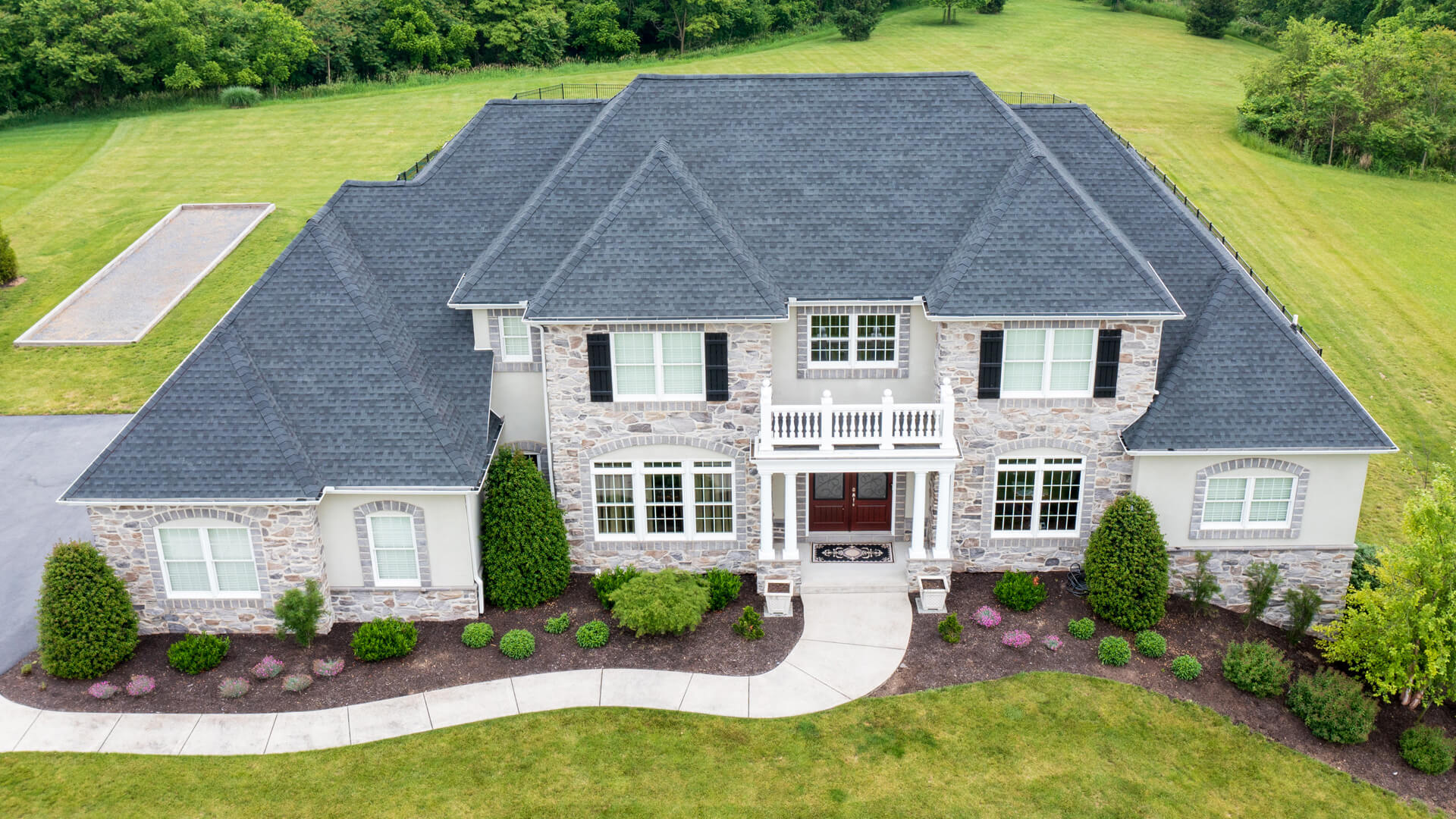 aerial view of home with shingle roof