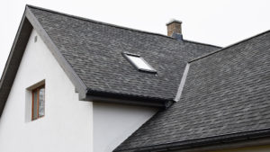 Roof with grey tiles, sunlight window and chimney