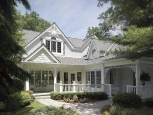 Hidden away home with white siding and gray asphalt shingle roof