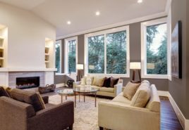 Spacious living room with large picture windows looking out at woods