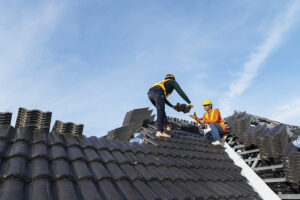 Construction workers installing a roof with tiles.