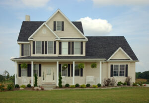 Large house with tan siding and a lush lawn